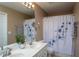 Bright bathroom featuring a double sink vanity, large mirror, and a shower/tub combo with a decorative curtain at 7244 Galon Glen Rd, Raleigh, NC 27613