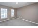 Comfortable bedroom featuring neutral carpet and paint, with two windows offering natural light at 7244 Galon Glen Rd, Raleigh, NC 27613