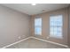 Cozy bedroom showcasing neutral carpet and paint, with two windows offering great natural light at 7244 Galon Glen Rd, Raleigh, NC 27613
