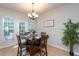 Dining room with wood table, chandelier, and natural light from the exterior door at 7244 Galon Glen Rd, Raleigh, NC 27613