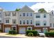 Charming townhome exterior featuring brick accents, a one-car garage, and colorful doors at 7244 Galon Glen Rd, Raleigh, NC 27613