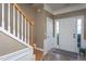 Inviting foyer with white trim, neutral paint, tile flooring, and a staircase at 7244 Galon Glen Rd, Raleigh, NC 27613