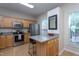 Kitchen view with stainless appliances, breakfast bar, and ample natural light at 7244 Galon Glen Rd, Raleigh, NC 27613