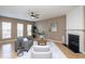 Cozy living room with fireplace, ceiling fan, and natural light at 7244 Galon Glen Rd, Raleigh, NC 27613