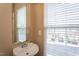 Cozy powder room featuring a pedestal sink and window with natural light at 7244 Galon Glen Rd, Raleigh, NC 27613