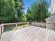 Spacious wooden back deck surrounded by wooden and wire fence with a lush tree lined backyard offering privacy at 8312 Bellingham Cir, Raleigh, NC 27615