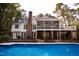 Backyard view of house with a screened-in porch, lower level patio and in-ground pool at 9200 Lake Carol Dr, Zebulon, NC 27597