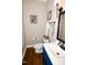 Updated powder room featuring blue vanity, dark fixtures, wood floors, and decorative accents at 9200 Lake Carol Dr, Zebulon, NC 27597