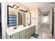Bright bathroom featuring double sinks, a large mirror, and a walk-in shower behind a blue patterned curtain at 9200 Lake Carol Dr, Zebulon, NC 27597