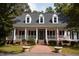 Charming home with a large porch, white columns and black shutters at 9200 Lake Carol Dr, Zebulon, NC 27597