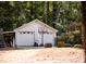 Detached two-car garage with basketball hoop and mature trees surrounding it at 9200 Lake Carol Dr, Zebulon, NC 27597