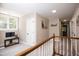Upstairs landing area with natural light, neutral carpet, and view of hallway with storage closets at 9200 Lake Carol Dr, Zebulon, NC 27597