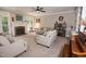 Inviting living room featuring neutral paint, large windows, fireplace with brick hearth, and ceiling fan at 9200 Lake Carol Dr, Zebulon, NC 27597