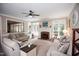 Spacious living room featuring neutral paint, carpet, large windows, ceiling fan and a brick fireplace at 9200 Lake Carol Dr, Zebulon, NC 27597