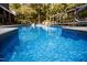 In-ground pool with clear blue water and mature trees around the backyard at 9200 Lake Carol Dr, Zebulon, NC 27597
