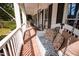 Inviting porch with brick floor, swing with decorative pillows and relaxing seating at 9200 Lake Carol Dr, Zebulon, NC 27597