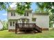 Back exterior view of a home with a wooden deck overlooking a sprawling green lawn and mature trees at 933 Richland Ridge Dr, Wake Forest, NC 27587