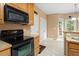 Kitchen with black appliances, wood cabinets, and tile flooring at 933 Richland Ridge Dr, Wake Forest, NC 27587