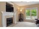 Cozy living room with a fireplace, built-in shelving, and a large window providing natural light at 933 Richland Ridge Dr, Wake Forest, NC 27587