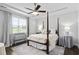 Bedroom with hardwood floors, large windows, canopy bed and ceiling fan at 1002 Gilly Ct, Durham, NC 27703