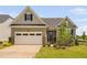 Charming single-Gathering home featuring a two-car garage, neutral siding, and professionally landscaped front yard at 1002 Gilly Ct, Durham, NC 27703