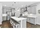 A spacious kitchen with grey cabinets, stainless steel appliances and a center island with seating for entertaining at 1002 Gilly Ct, Durham, NC 27703
