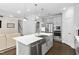 Open kitchen showcases stainless appliances, a large island with sink and dishwasher, and hardwood floors at 1002 Gilly Ct, Durham, NC 27703