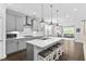 Modern kitchen featuring gray cabinetry, a large island with seating, stainless steel appliances, and hardwood flooring at 1002 Gilly Ct, Durham, NC 27703