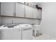 Laundry room equipped with modern washer, dryer, sink, and ample cabinet space at 1002 Gilly Ct, Durham, NC 27703