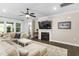 Well-lit living room featuring a fireplace, mounted TV, large windows, and comfortable sectional seating at 1002 Gilly Ct, Durham, NC 27703