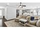 Open-concept living room featuring a sectional sofa, ceiling fan, and open access to kitchen and dining areas at 1002 Gilly Ct, Durham, NC 27703