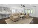 Open-concept living room featuring a sectional sofa, ceiling fan, and open access to kitchen and dining areas at 1002 Gilly Ct, Durham, NC 27703