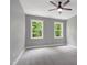 Light filled bedroom with two large windows and ceiling fan at 1003 E Sterlington Pl, Apex, NC 27502