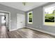Bright bedroom features two windows, light gray walls, and wood-look flooring with walk-in closet at 1003 E Sterlington Pl, Apex, NC 27502