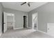 Spacious bedroom with plush carpet, neutral paint, and multiple doorway access points at 1003 E Sterlington Pl, Apex, NC 27502