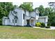 Modern two-story home boasts bright white siding, a manicured lawn, and mature trees at 1003 E Sterlington Pl, Apex, NC 27502
