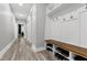 Well-lit hallway features wood-look flooring and a built-in mudroom bench with shoe storage at 1003 E Sterlington Pl, Apex, NC 27502