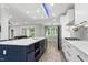 Bright open kitchen with navy island, white cabinetry, stainless appliances, and hardwood floors at 1003 E Sterlington Pl, Apex, NC 27502