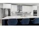 Kitchen island with seating, white cabinets, subway tile backsplash and modern fixtures at 1003 E Sterlington Pl, Apex, NC 27502