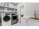 Functional laundry room with modern appliances, counter space and open shelving at 1003 E Sterlington Pl, Apex, NC 27502