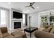 Living room with fireplace, TV, hardwood floors, and sliding doors to the backyard at 1003 E Sterlington Pl, Apex, NC 27502