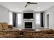 Living room with fireplace and mounted TV with gray walls and hardwood floors at 1003 E Sterlington Pl, Apex, NC 27502