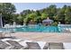 Community swimming pool with lounge chairs and mature trees at 1003 E Sterlington Pl, Apex, NC 27502
