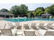 Community swimming pool with lounge chairs surrounded by shade trees and greenery at 1003 E Sterlington Pl, Apex, NC 27502