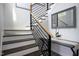 Elegant staircase with modern railing and table with decor and mirror at 1003 E Sterlington Pl, Apex, NC 27502