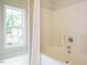 Bright bathroom showcasing a tub with shower and a window overlooking the yard at 1010 Starita Ct, Apex, NC 27502