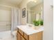 Bathroom with tub-shower, tiled floors, and a mirror over the single vanity at 1010 Starita Ct, Apex, NC 27502