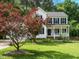 Classic white home featuring a covered porch and a mature maple tree at 1010 Starita Ct, Apex, NC 27502