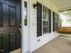 Cozy front porch with swing, black door, and black framed window at 1010 Starita Ct, Apex, NC 27502