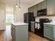 Updated kitchen with painted cabinets, stainless steel appliances, and modern lighting at 1010 Starita Ct, Apex, NC 27502